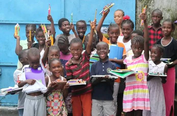 Children holding learning materials provided through the Child Rights to Education Project